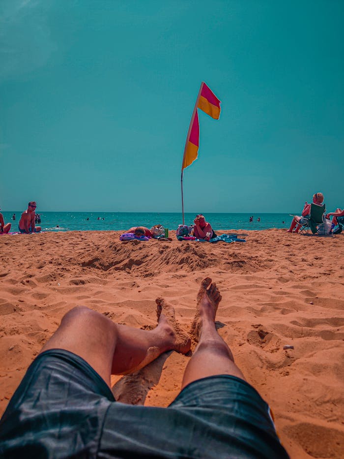 Enjoy a sunny day at Bournemouth beach with clear skies and vibrant flags.